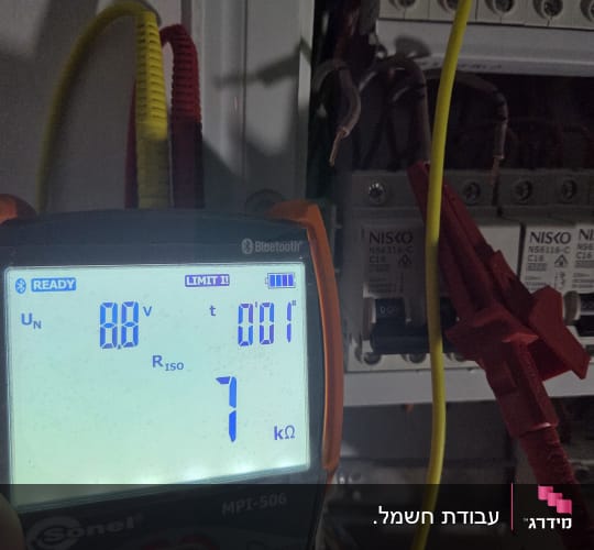 מד מתח חשמלי ליד לוח חשמל פתוח
